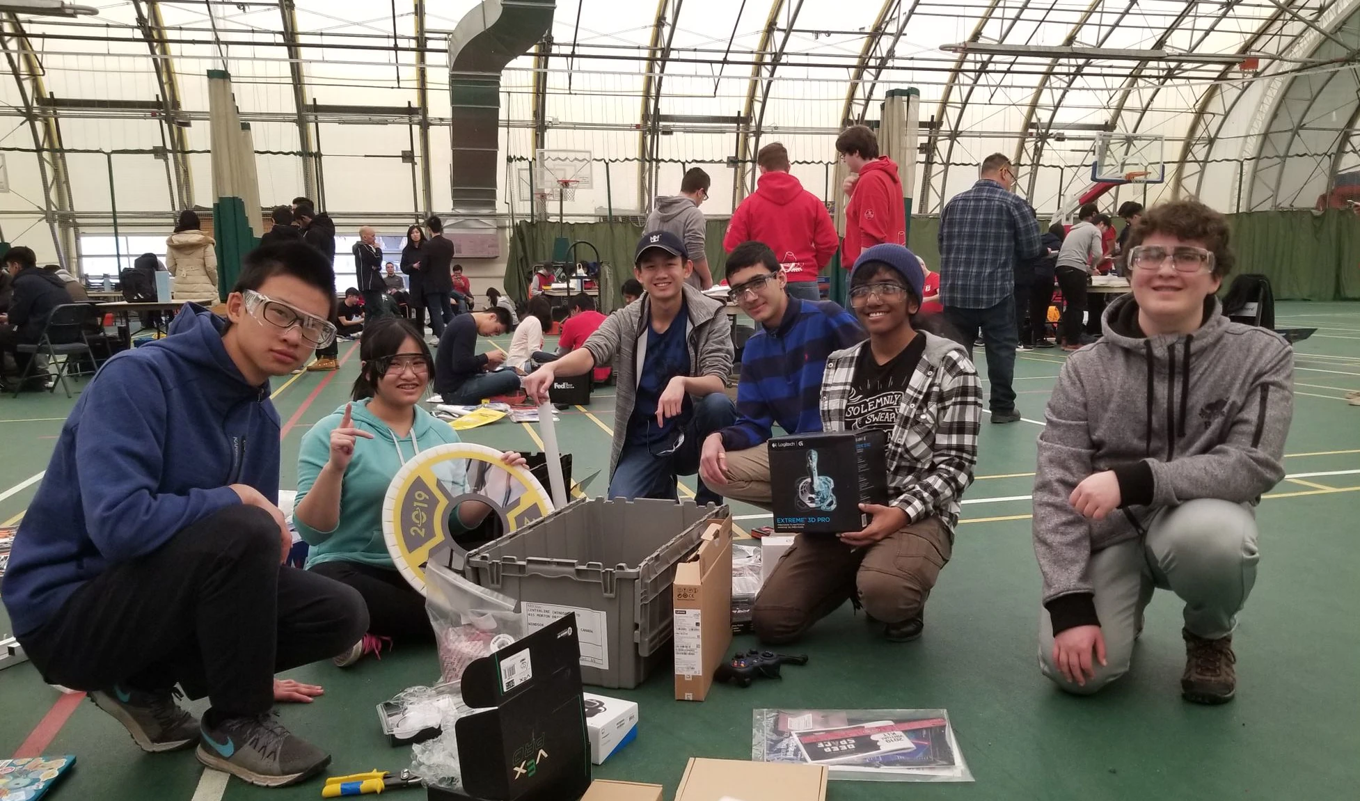 Team 7902 members posing with our first kit of parts, containing starting components and game pieces.